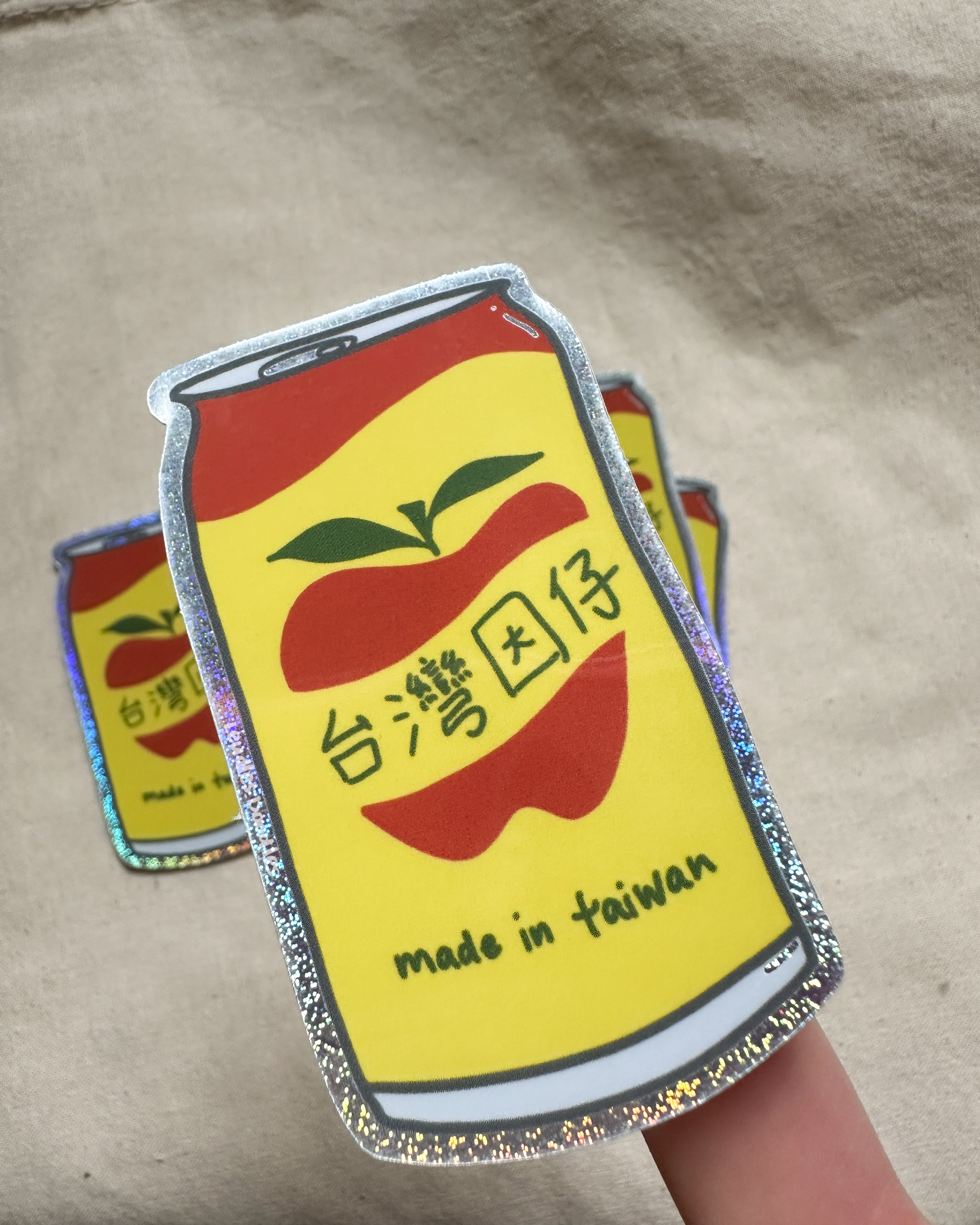 a sticker of Apple Sidra, a yellow soda can with "made in taiwan" on the label. The sticker has a glitter effect in the background and outline